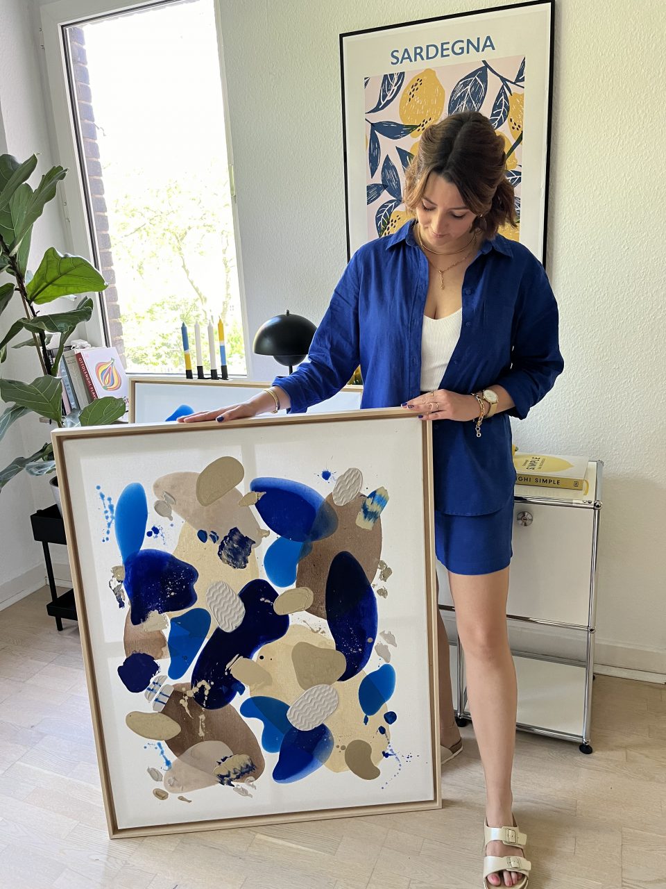Frau mit Acrylbildern mit Struktur Azurblau
