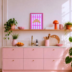 moderne skandinavische Küche ohne Oberschränke in Rosa wie METHOD von Ikea. Darüber ist ein modernes Kunstwerk auf einem Holzregal. Zu sehen ist ein gestreifter Hintergrund in Pink/ Weiß und das Croissant ist aus Strukturpaste.